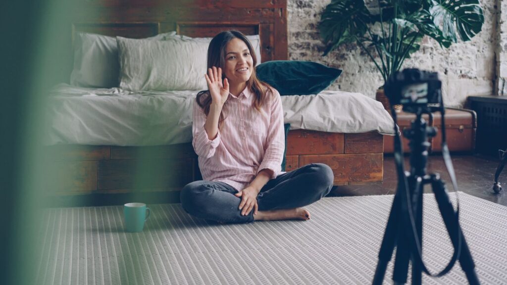 Young woman filming a lifestyle vlog indoors with natural light.
